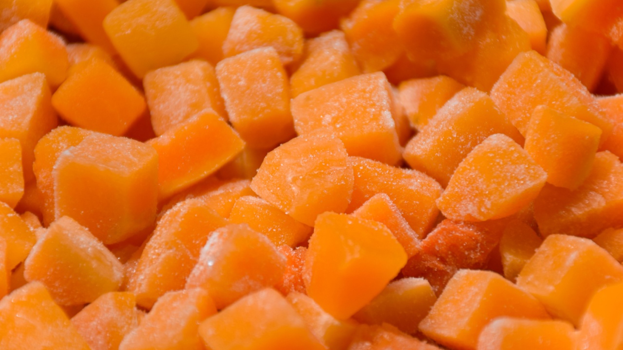 Roughly cut in cubes frozen butternut squash background with selective focus