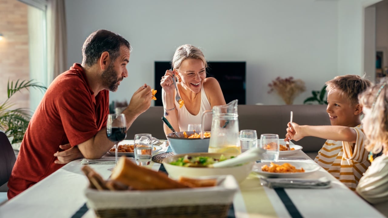 Shot of beautiful kind family talking while eating together in the kitchen at home