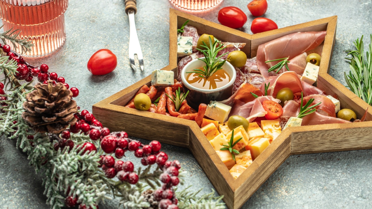 Christmas theme charcuterie board. Mixed cheese and meat with rose wine antipasto, Christmas holidays, place for text, top view.