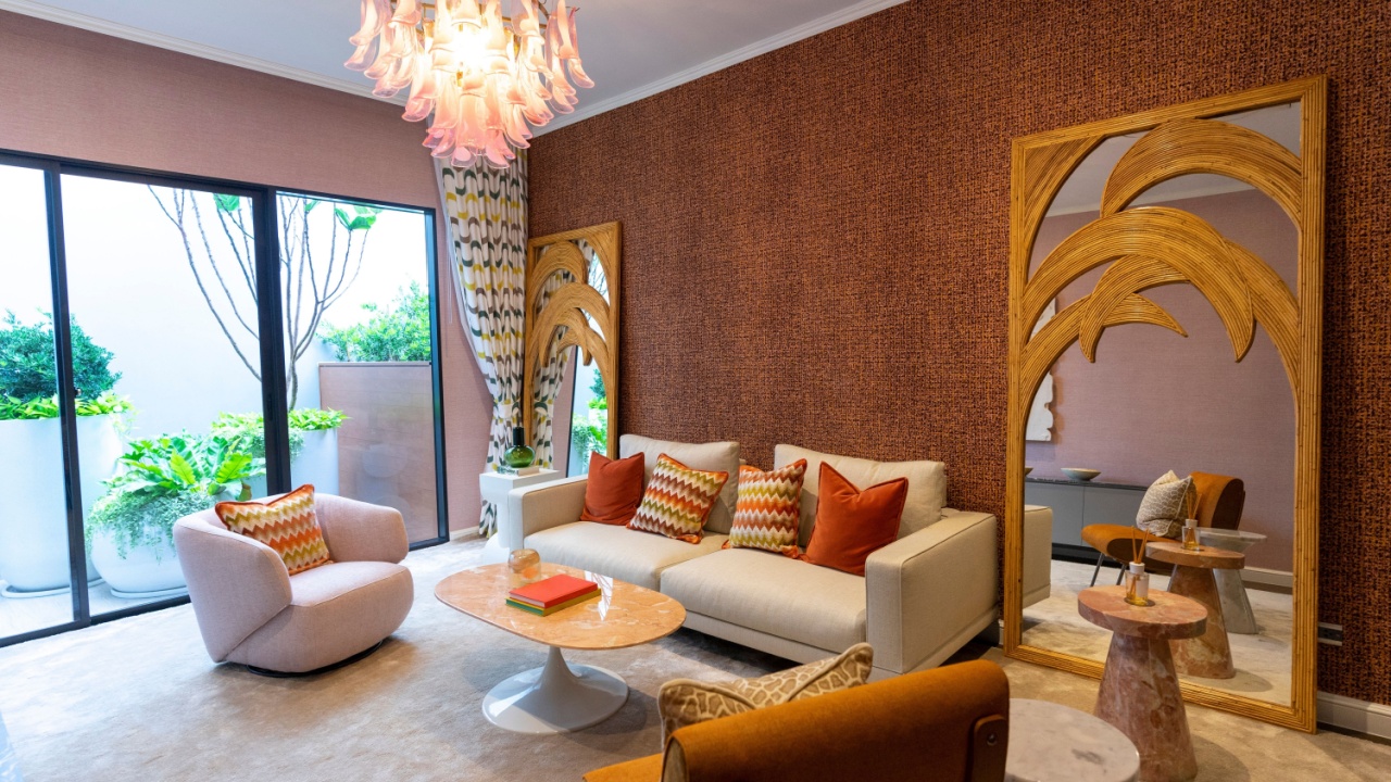 Living room in art Deco style with grey and brown upholstered designer furniture. With a large wooden mirror on wall.