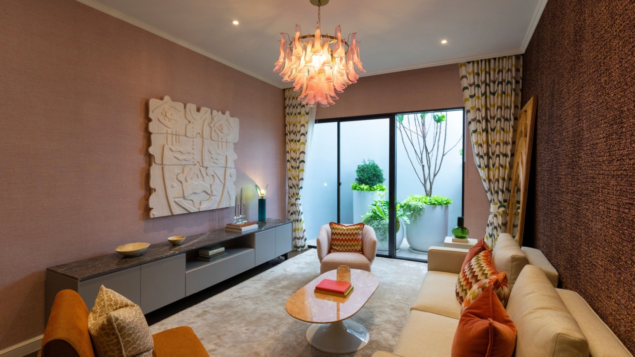 Living room in art Deco style with grey and brown upholstered designer furniture. With a large wooden mirror on wall.