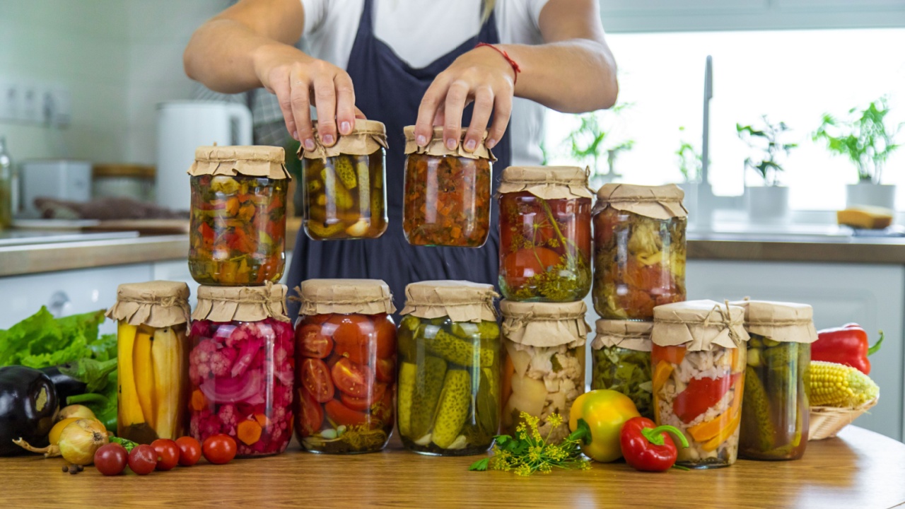 Woman canning vegetables in jars in the kitchen. Selective focus. Food.