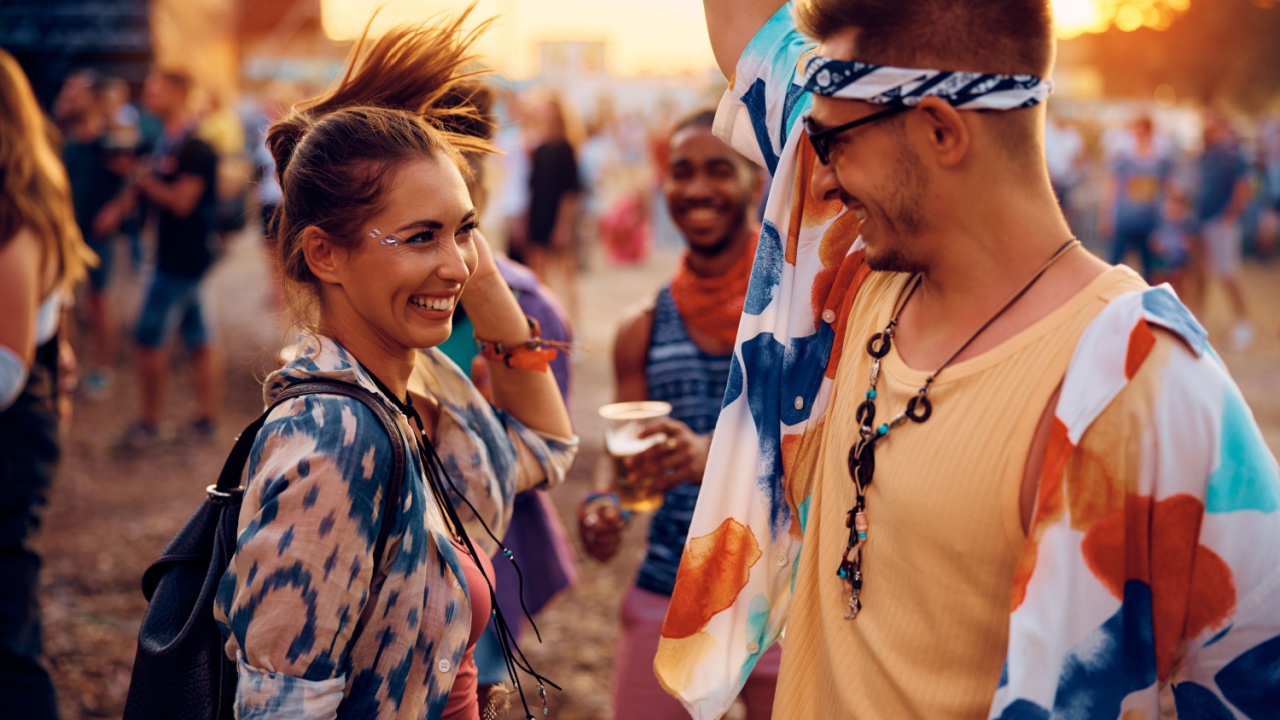 Young couple having fun and dancing on a music concert in summer.