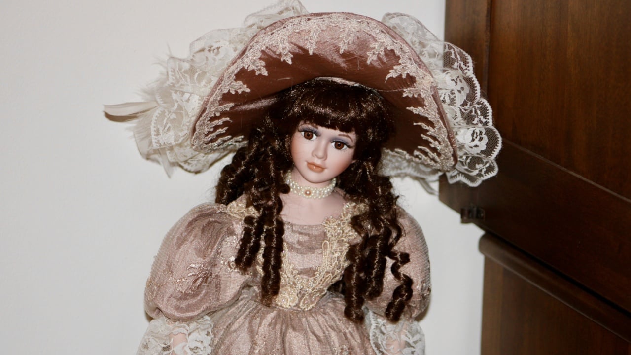 Deer Park, NY, USA, 2.5.23 - A porcelain doll with a Victorian style hat.
