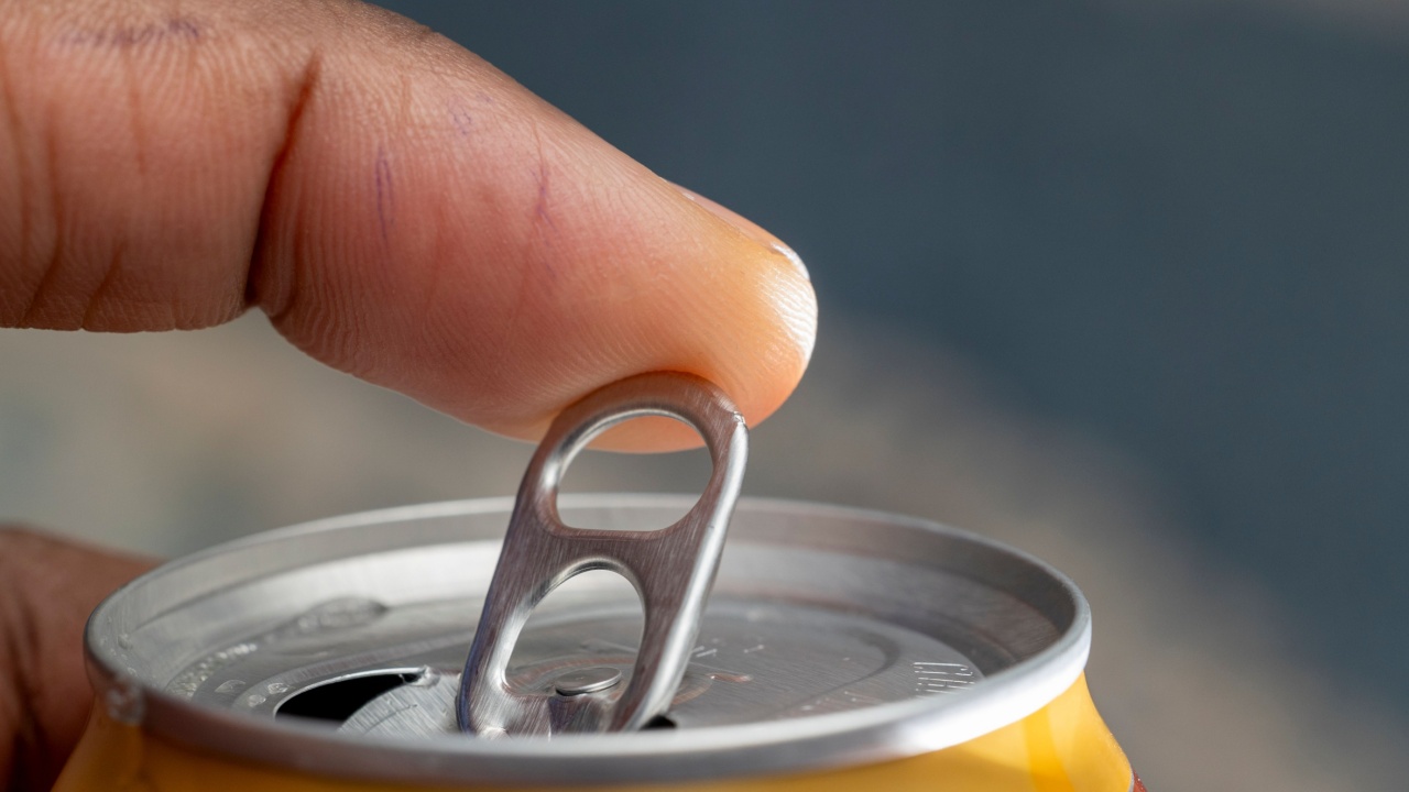 Finger opening a soda can, moment of refreshment