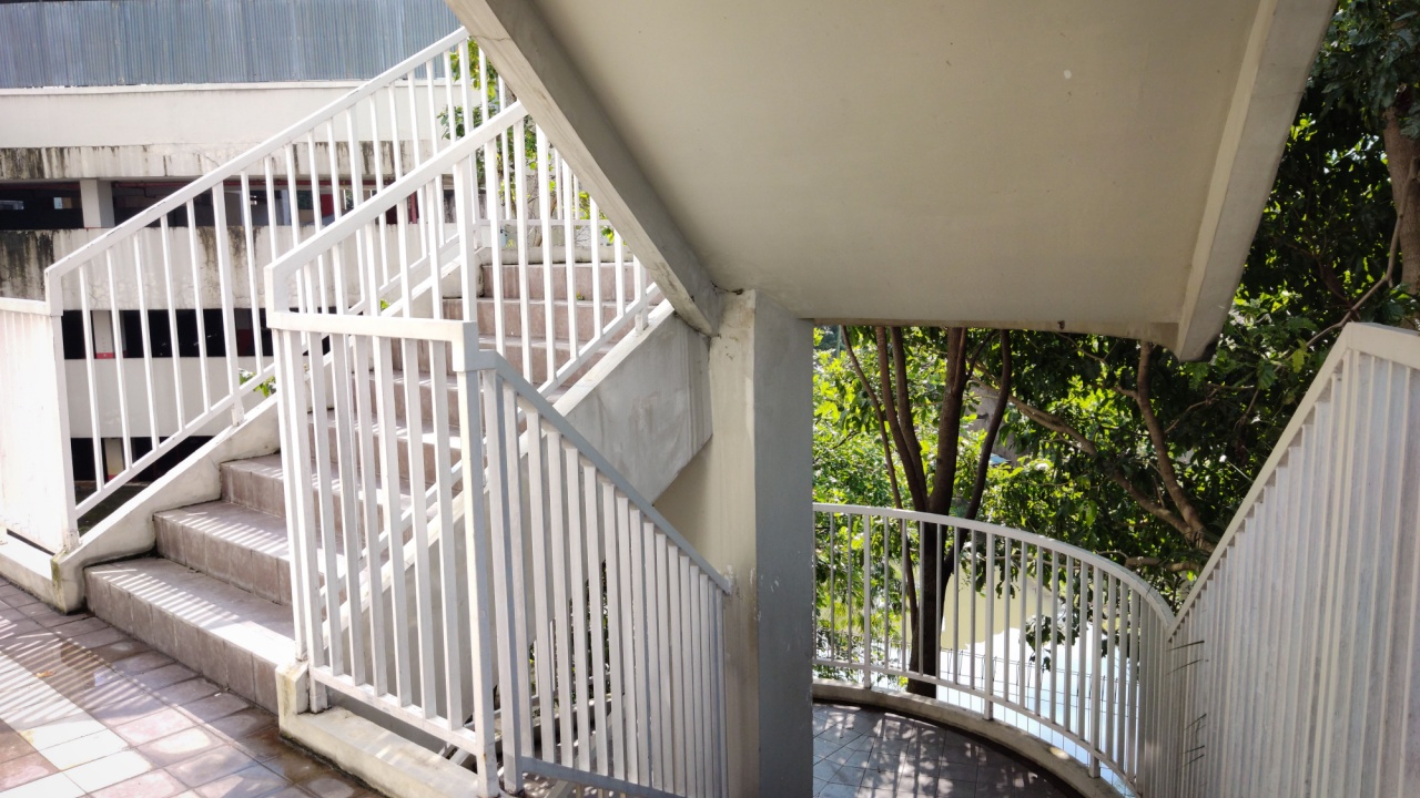 Outdoor staircase for emergency exit in an old apartment with overcast shadow