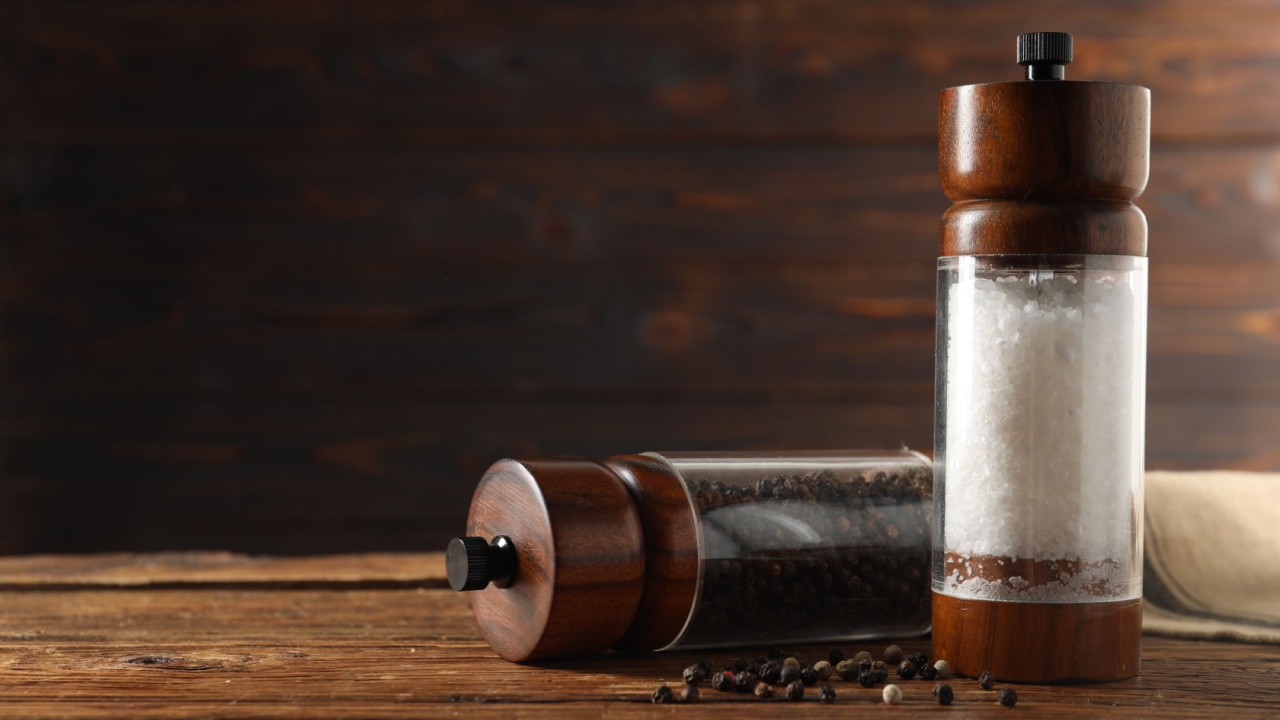 Salt and pepper shakers on wooden table, space for text