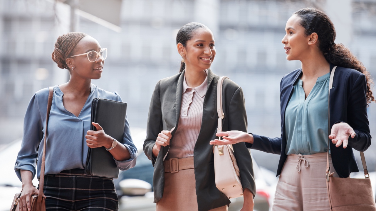 Discussion, city and business women walking on commute, travel and journey in conversation. Professional, corporate team and people in urban town talking for planning, communication and networking