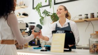Service, barista or customer with coffee shop or store for drinks or return at checkout counter in a cafe job. Reusable bottle, giving or waitress in small business restaurant with a woman or lady