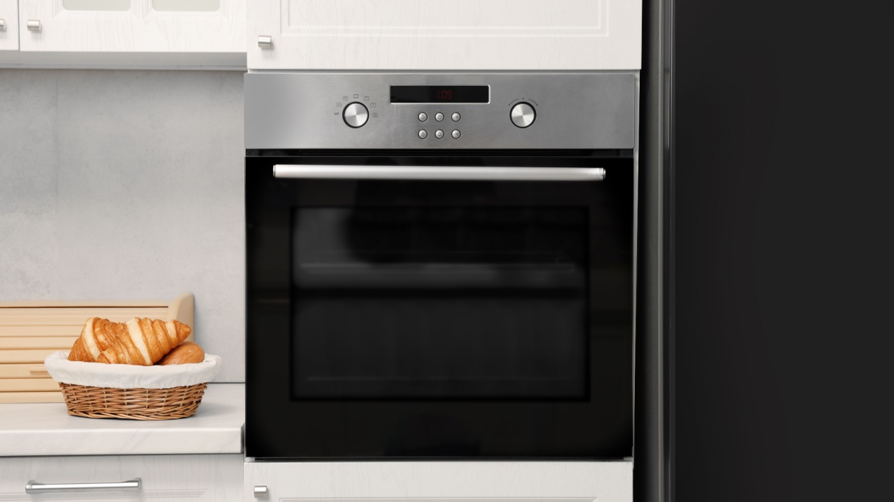 Electric oven and croissants in kitchen. Cooking appliance
