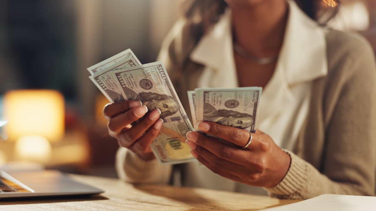 Hands, home and counting cash for budget, savings or profit from trading with laptop in night. Person, money and planning for investment, bills or payment with dollar, decision and computer in house