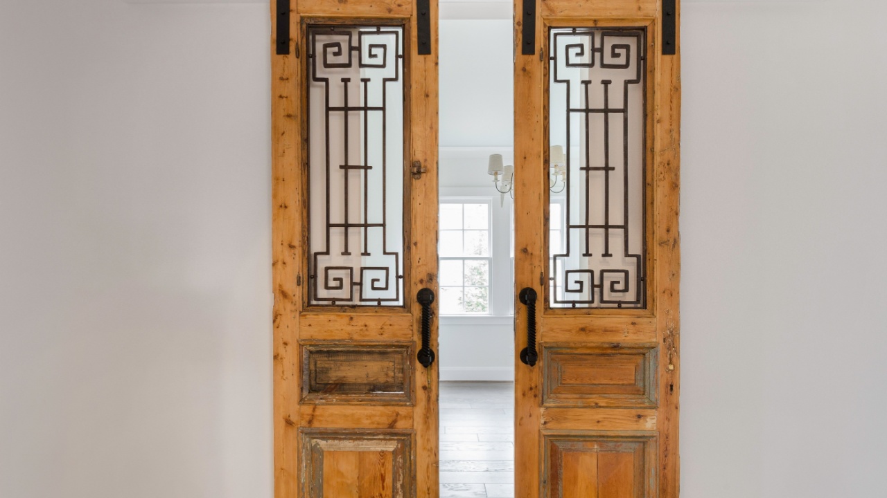 Vintage Sliding Barn Doors With Intricate Ironwork Details In The Living Room