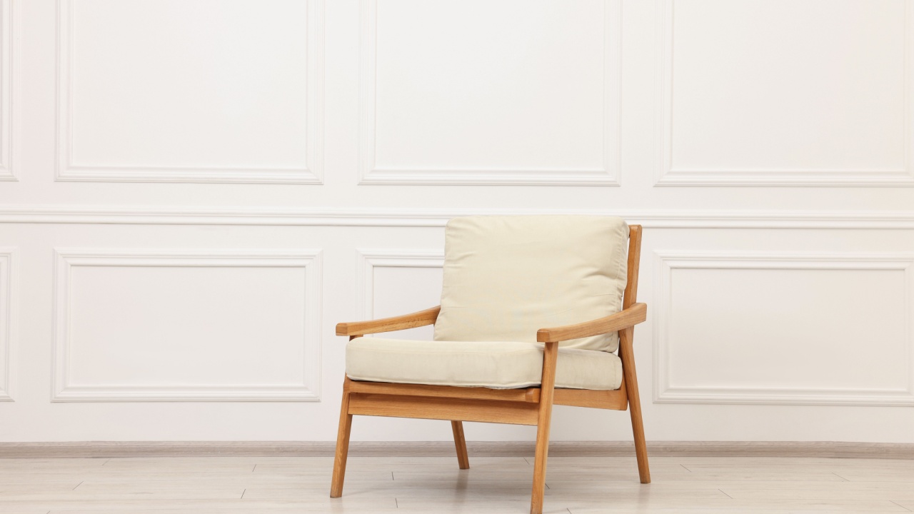 One comfortable soft armchair near white wall
