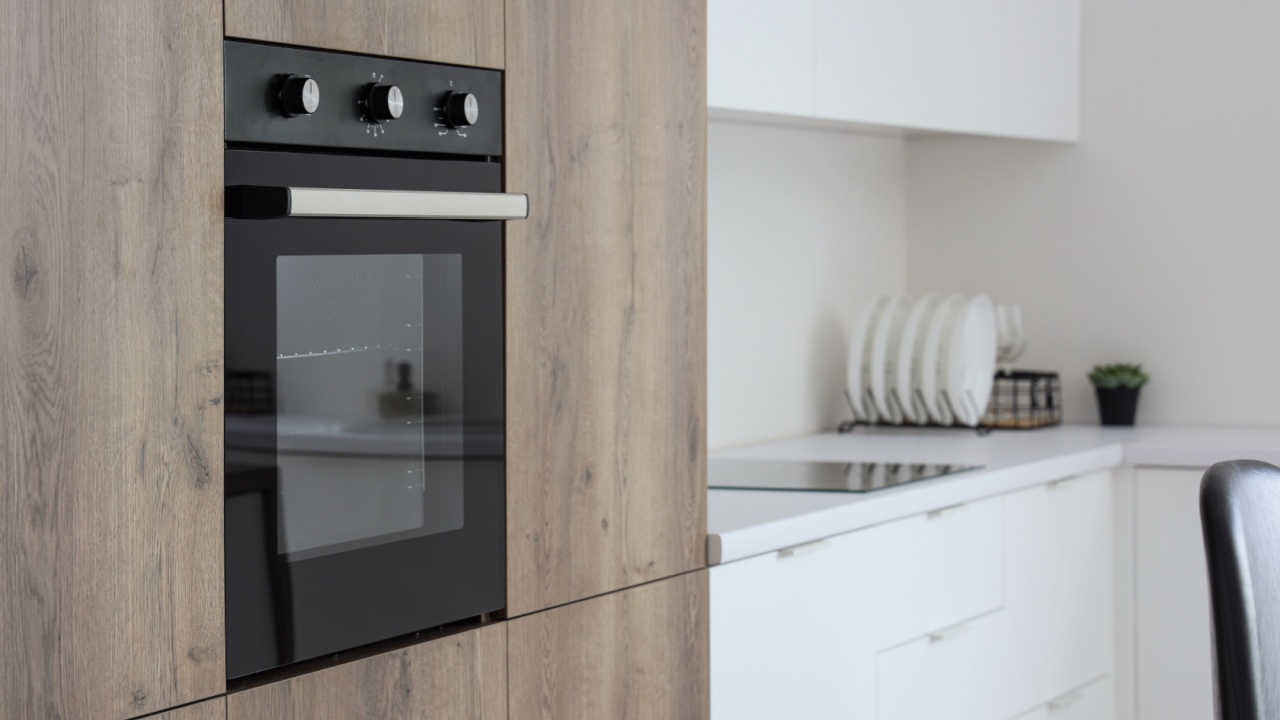 Wooden furniture with modern built-in oven in kitchen