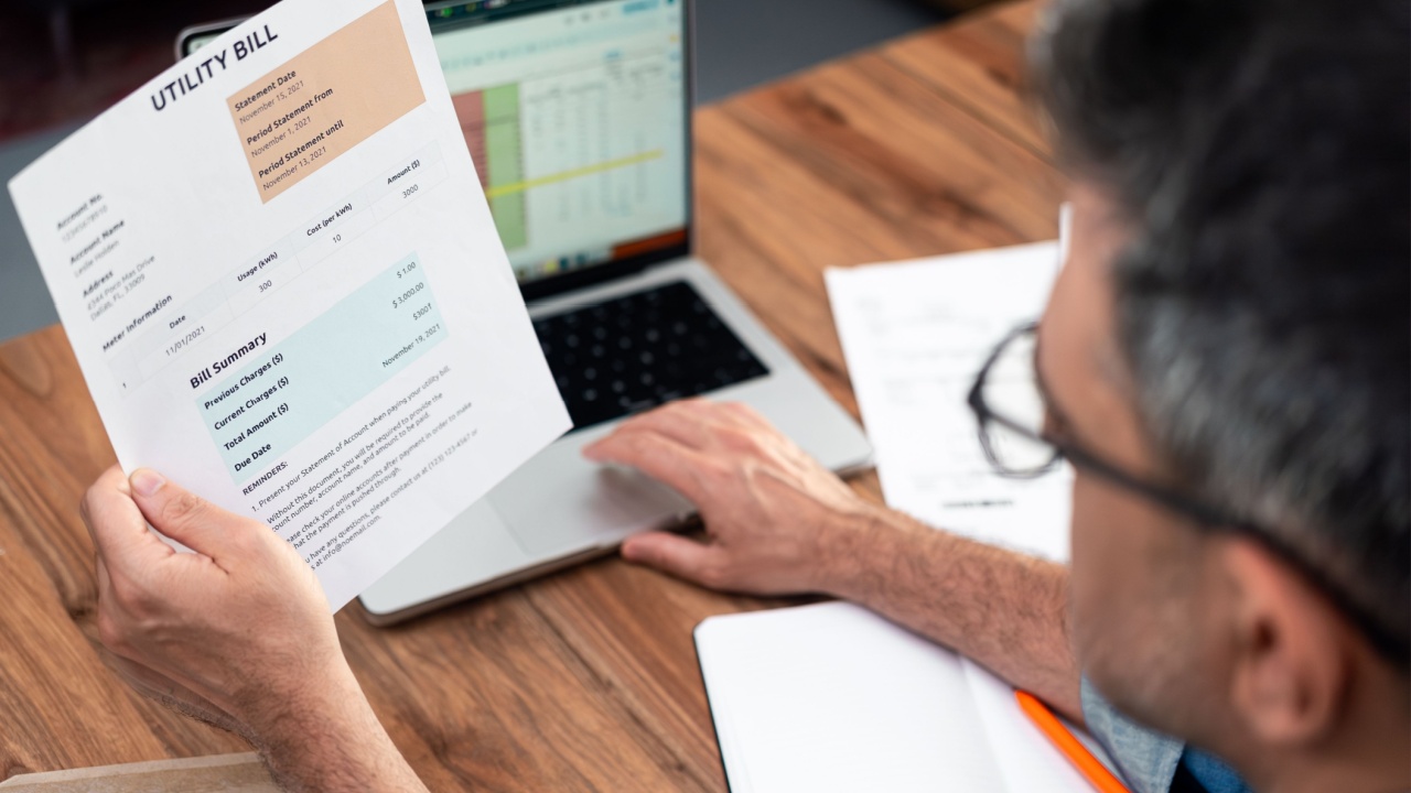 Aged man pays for utility bill with online banking working on laptop, mature male accountant controls household expense data with online tables, monthly payments invoice