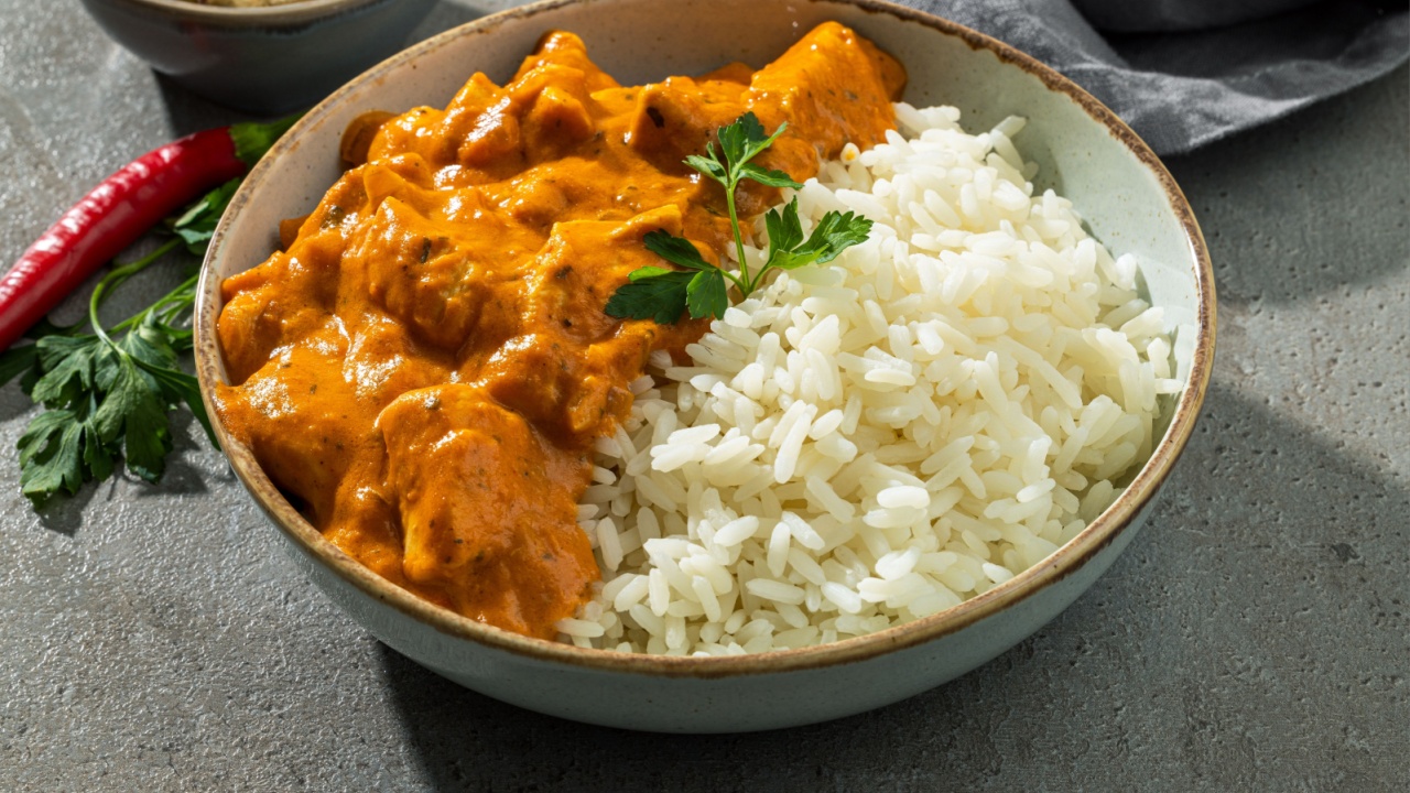 bowl of Chicken Tikka Masala with Rice on dark grey indian restaurant table