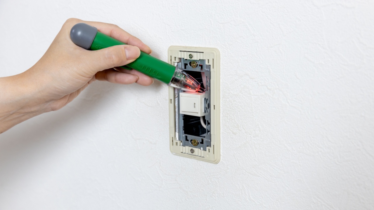 Electrician hands checking presence of electrical voltage.
