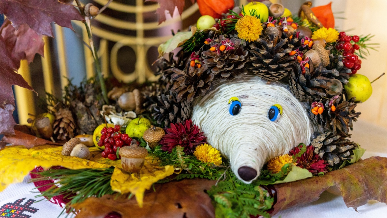 A whimsical representation of a hedgehog crafted from pinecones, colorful leaves, and berries. Set against a decorative background, it captures the essence of autumn crafting and nature's beauty.