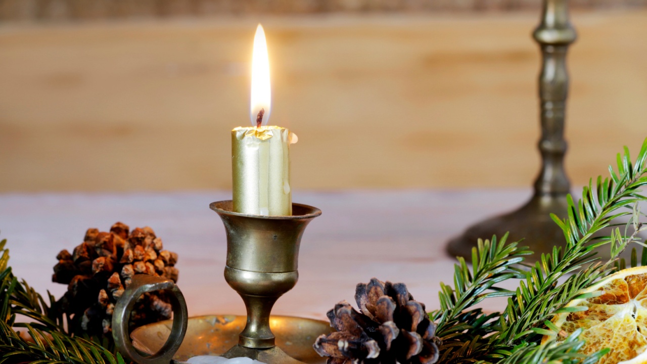 Traditional Christmas decorations with fir garland and dried oranges. Small candle holder in front of it.