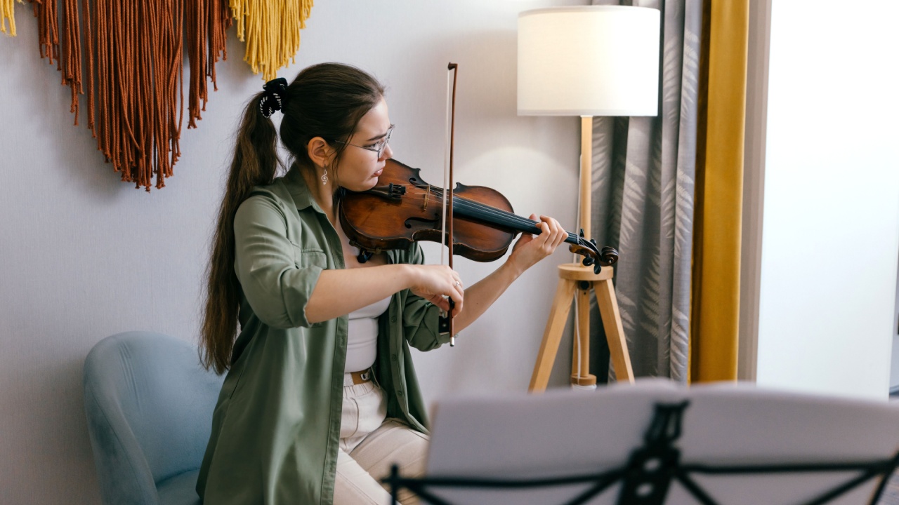 Focused young artist playing violin and studying music composition A dedicated violin student practices classical compositions, focusing on precision and technique