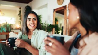 Advice, coffee and friends with women on sofa for bonding, relax and social reunion. Discussion, caffeine and drink with people talking in living room at home for chat, news and connection together