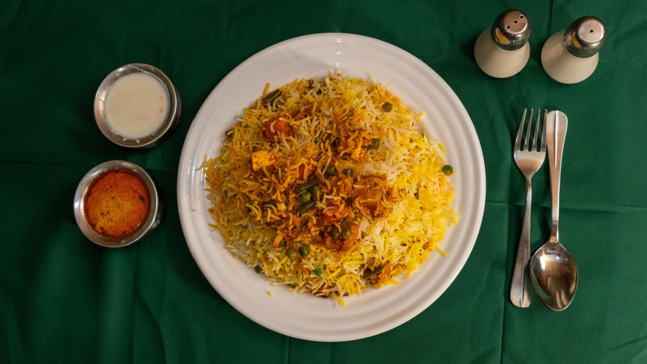 Vibrant top shot of aromatic vegetable biryani served on a white plate, garnished with fresh herbs, showcasing a flavorful vegetarian feast