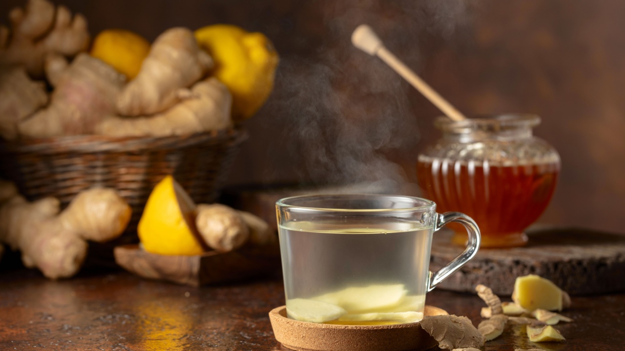 Ginger tea with lemon and honey on a brown background.