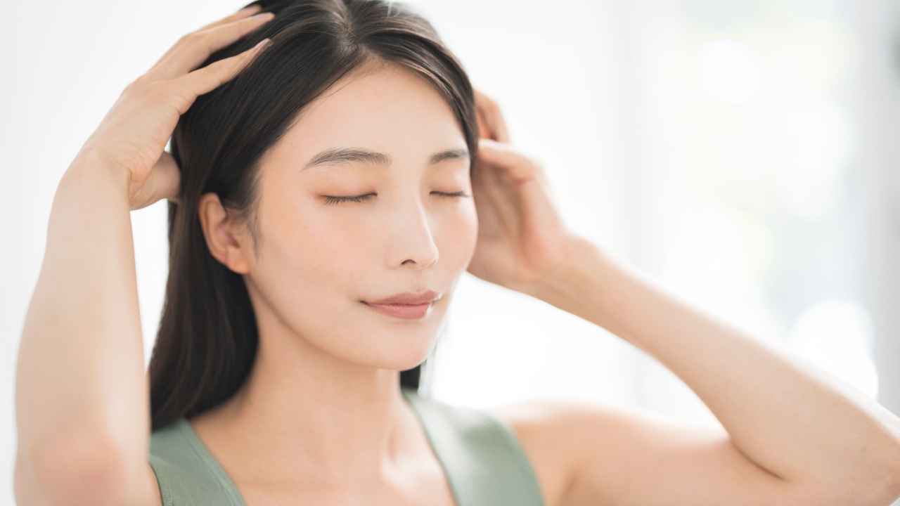 A woman doing a head massage with both hands.