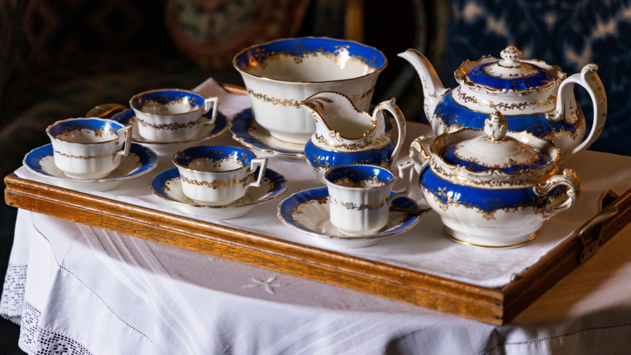 An exquisite porcelain tableware set graces Dunrobin Castle’s dining room, adorned with delicate floral motifs and gilded edges. Each piece, from fine china plates to elegant teacups, reflects the art