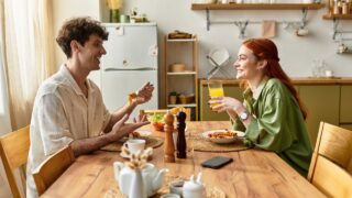 Young couple enjoys a delightful meal at home, sharing laughter and quality moments over food.