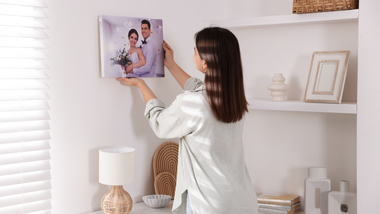 Canvas print. Woman hanging photo on wall at home