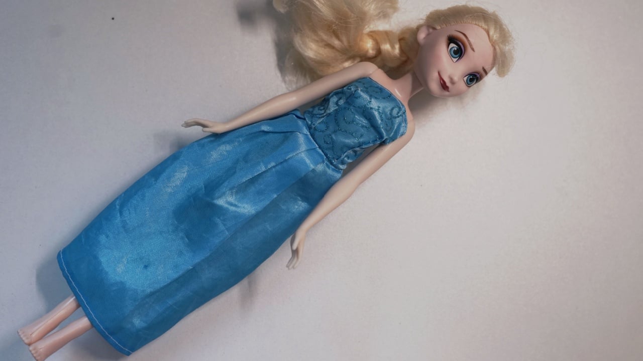 Gdansk, Poland - 04.04.2025 - Disney princess Elsa doll Frozen in blue long dress on white background kids play game children girl