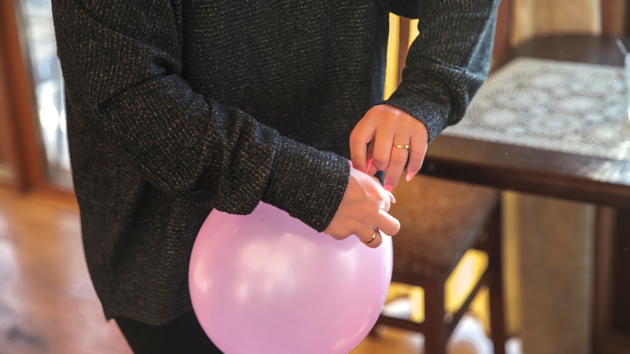 Woman tying a pink balloon at home before celebration