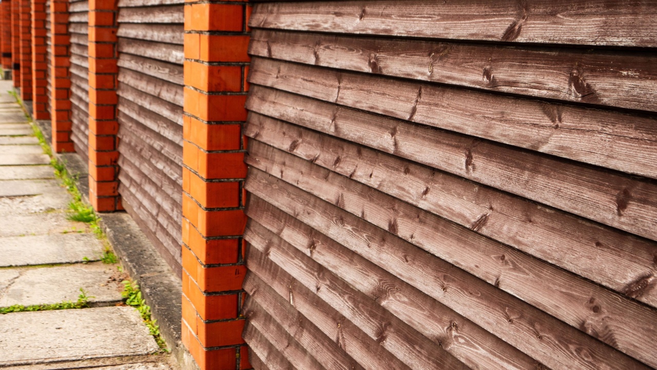 Red brick and wood fence. Mixing different materials for making a special look. Construction design.