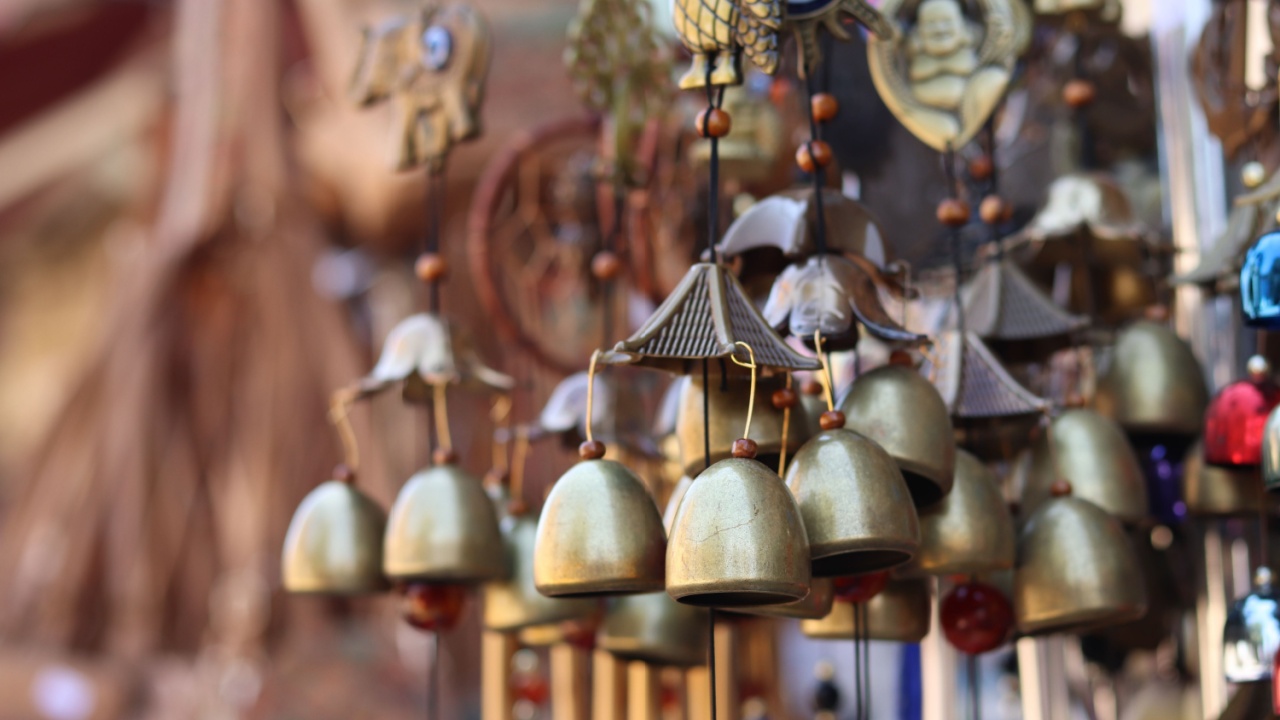 Souvenirs in the form of hanging golden bells, close-up. Souvenir market. Hanging bells used for home decoration. Group of bells with selective focus