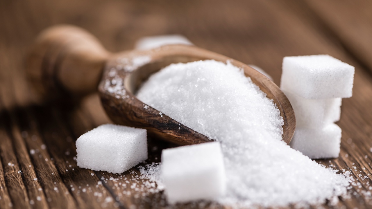 Portion of White Sugar (detailed close-up shot; selective focus) on wooden background