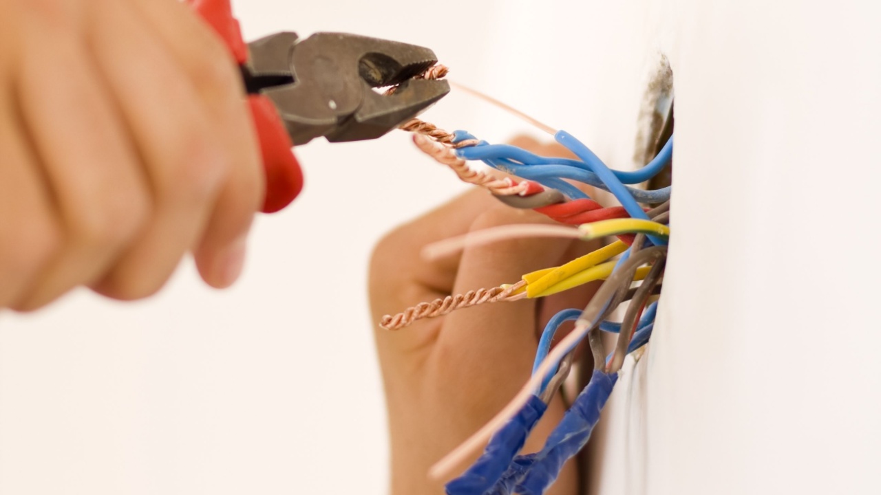 An electrician binding copper wires together and sealing them with insulation stripe.