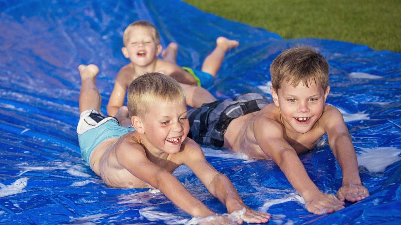Happy kids playing on a slip and slide outdoors
