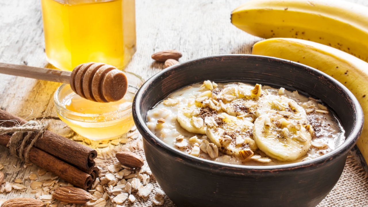 oatmeal porridge in dark ceramic bowl. with honey, banana, cinnamon and nuts. healthy breakfast. close up