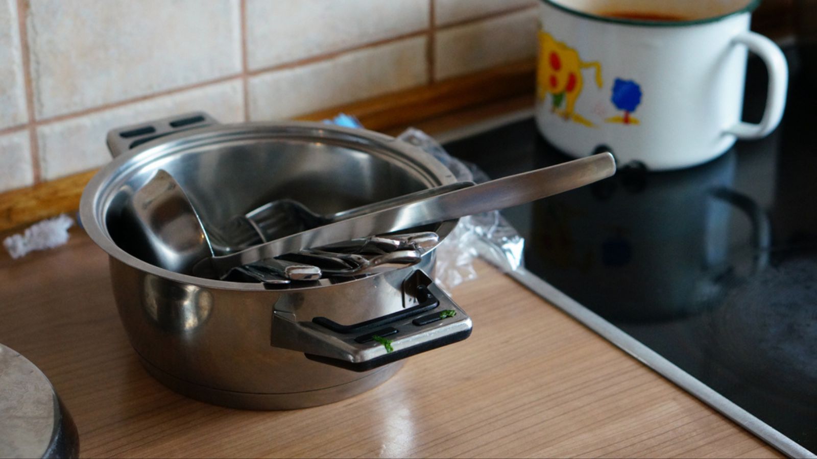 The aluminum pan with other kitchen utensils on the kitchen counter
