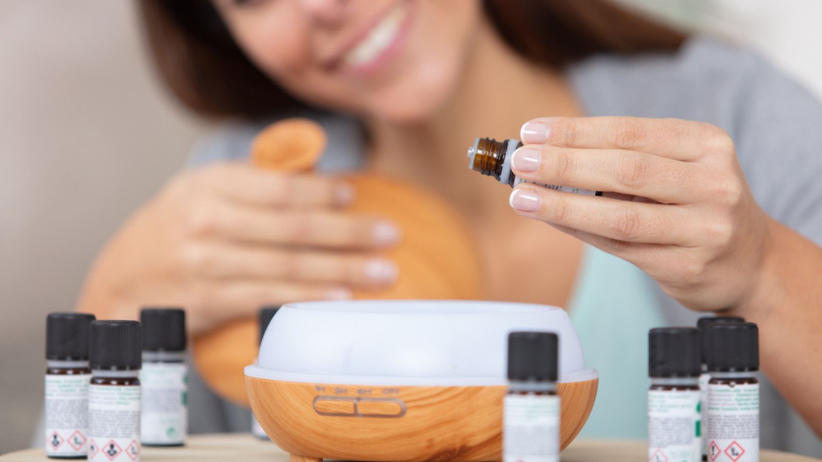 Woman dripping essential oils into a diffuser