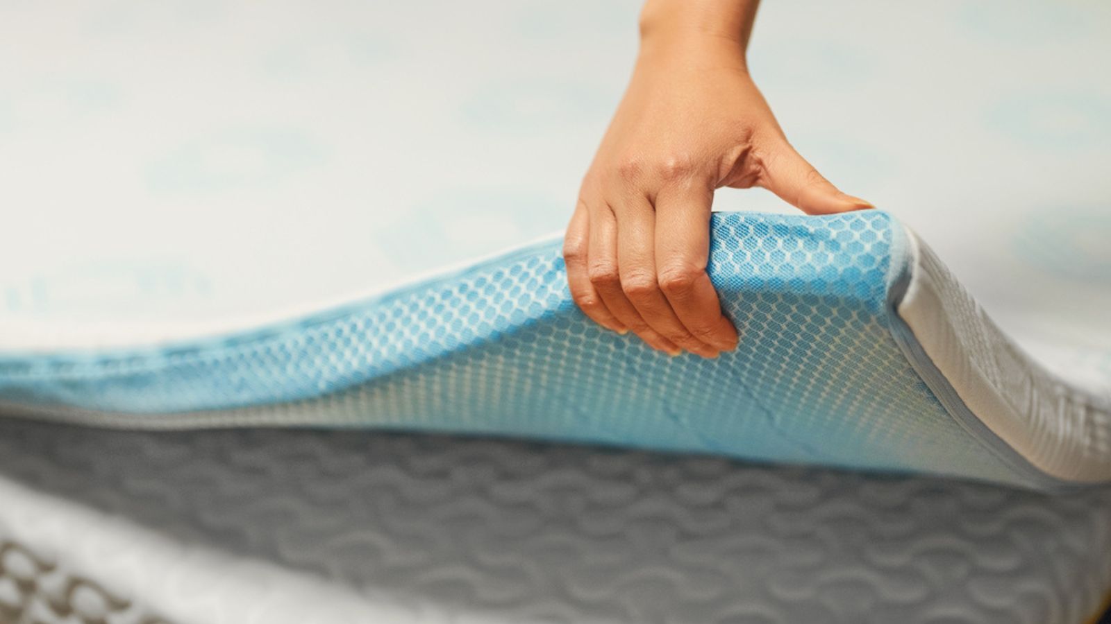 Woman hand testing orthopedic memory foam mattress topper.