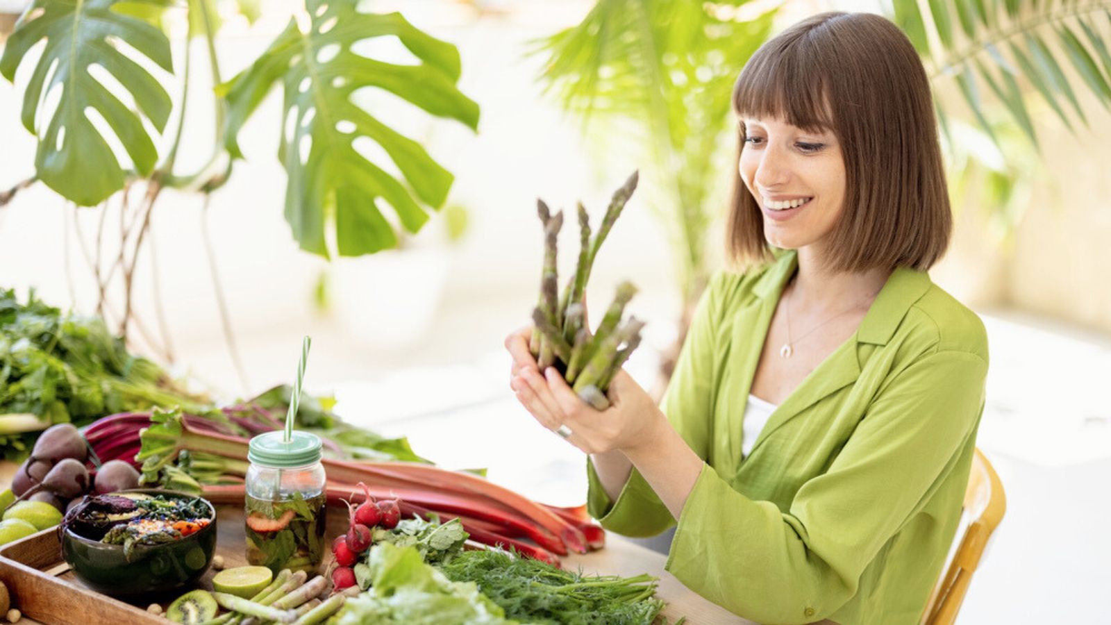 Woman with fresh healthy food ingredients indoors asparagus
