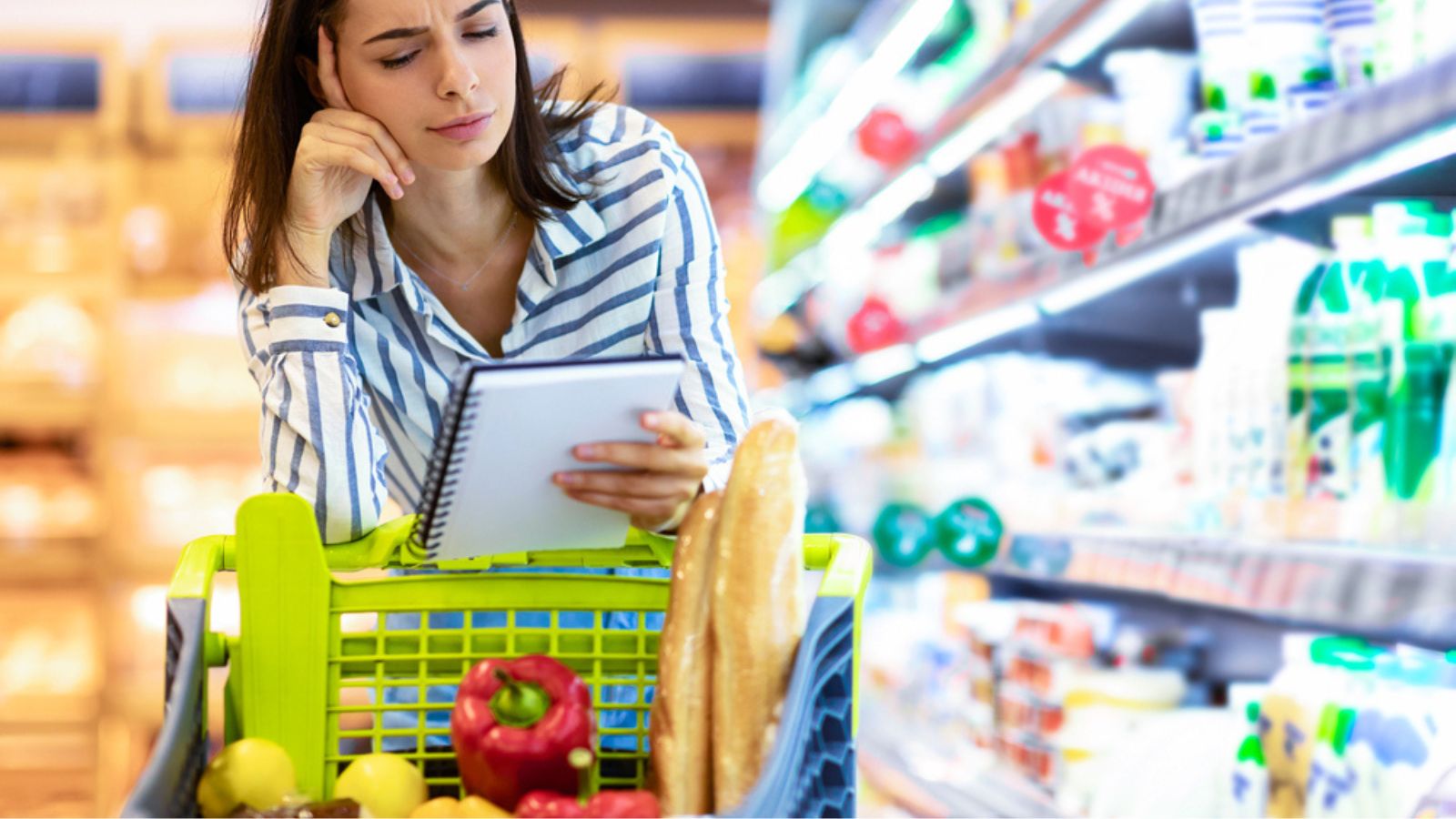 Young woman with shopping list in supermarket