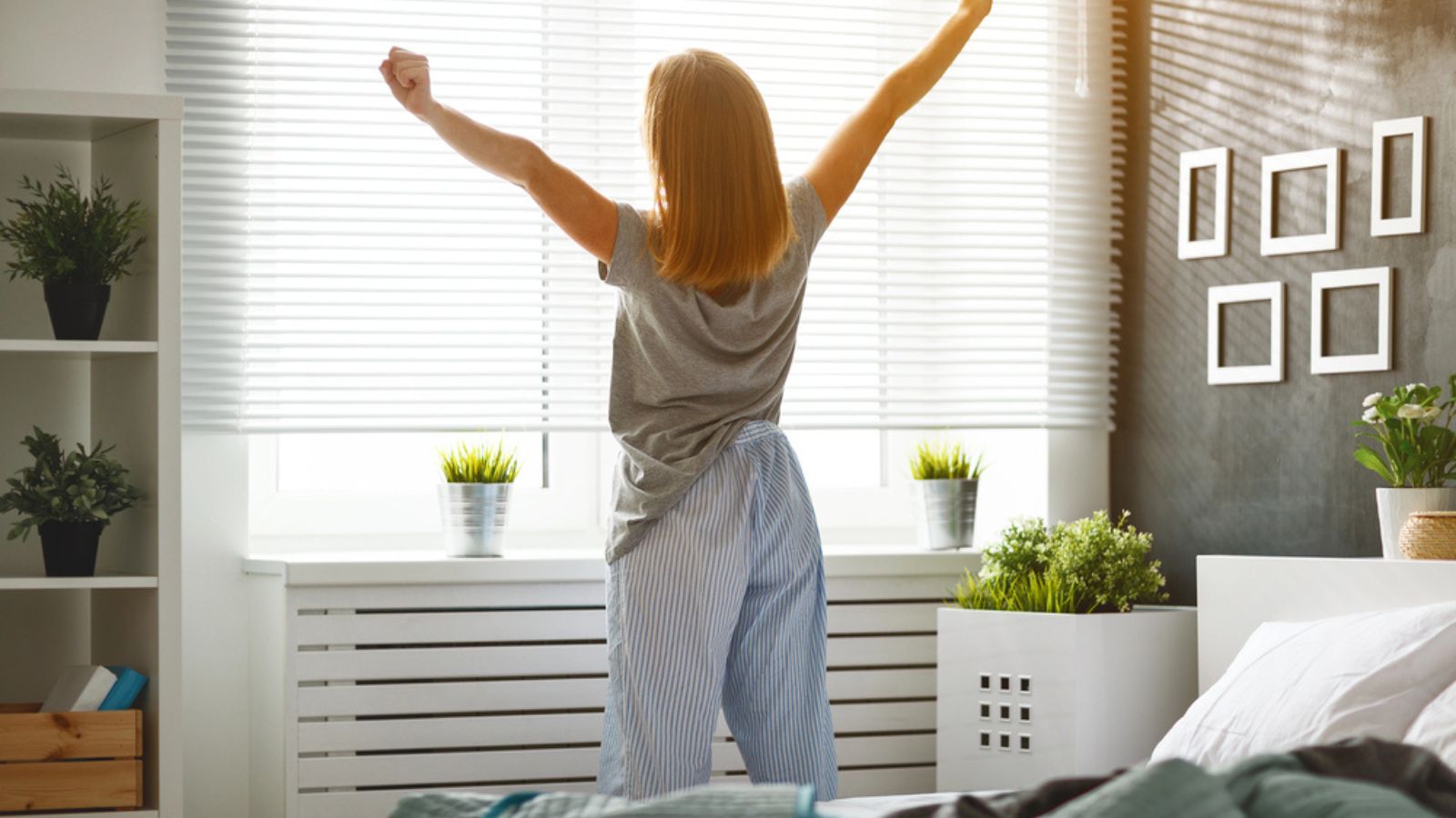 Young woman woke up in the morning in the bedroom by the window