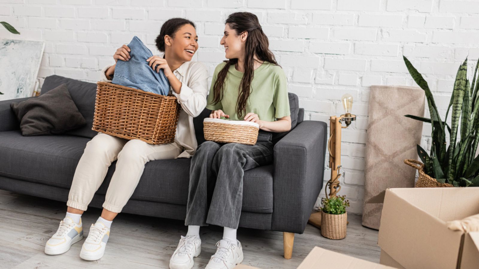 friends holding wicker baskets while sitting on sofa next to plants