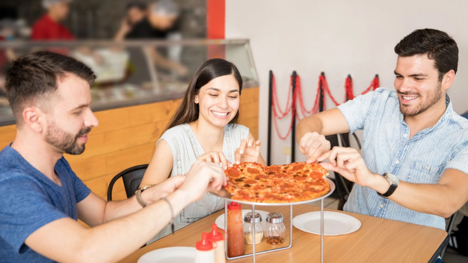 men and woman eating enjoying pizza in shop store chain restaurant cafe