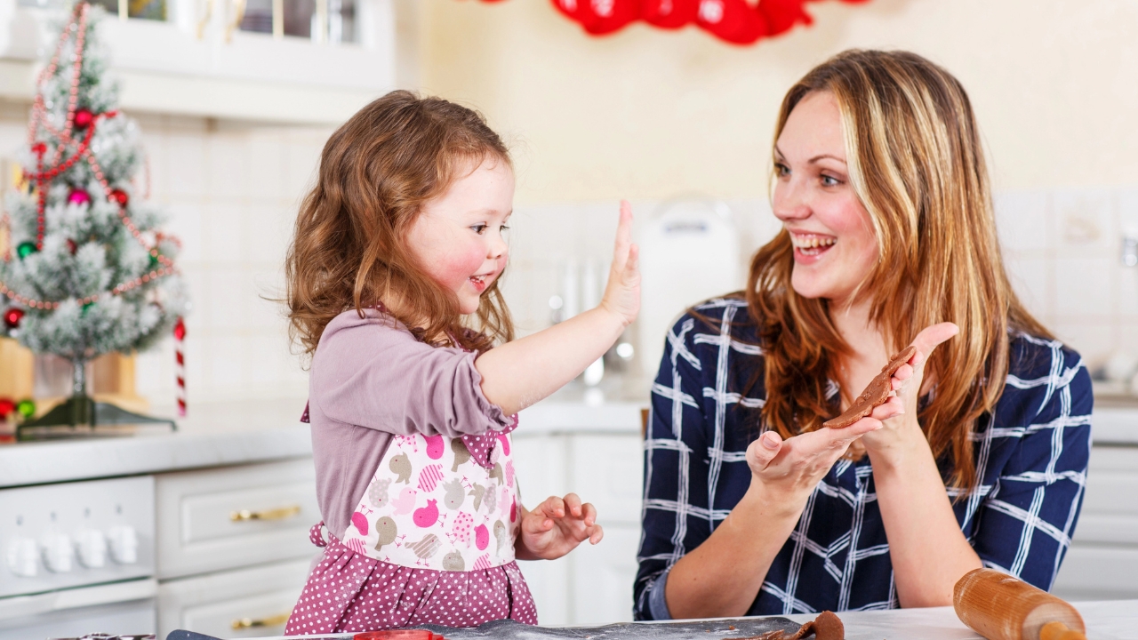a mother and daughter bake Christmas cookies together