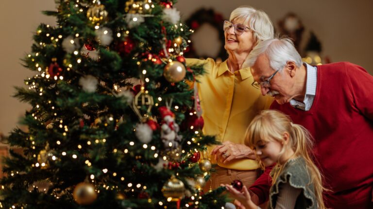 Grandparents and little girl decorate a Christmas tree