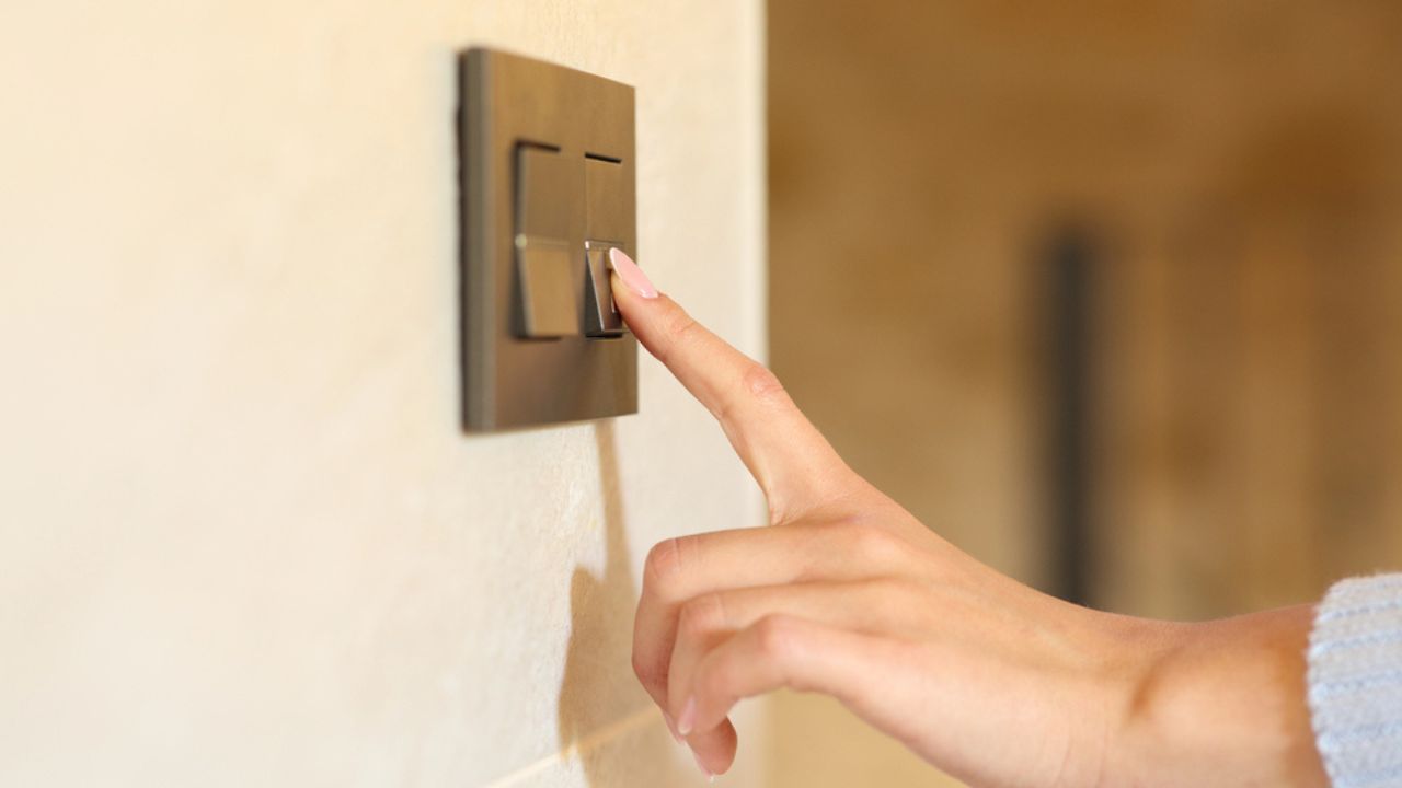Close up of a woman hand pushing light switch at home
